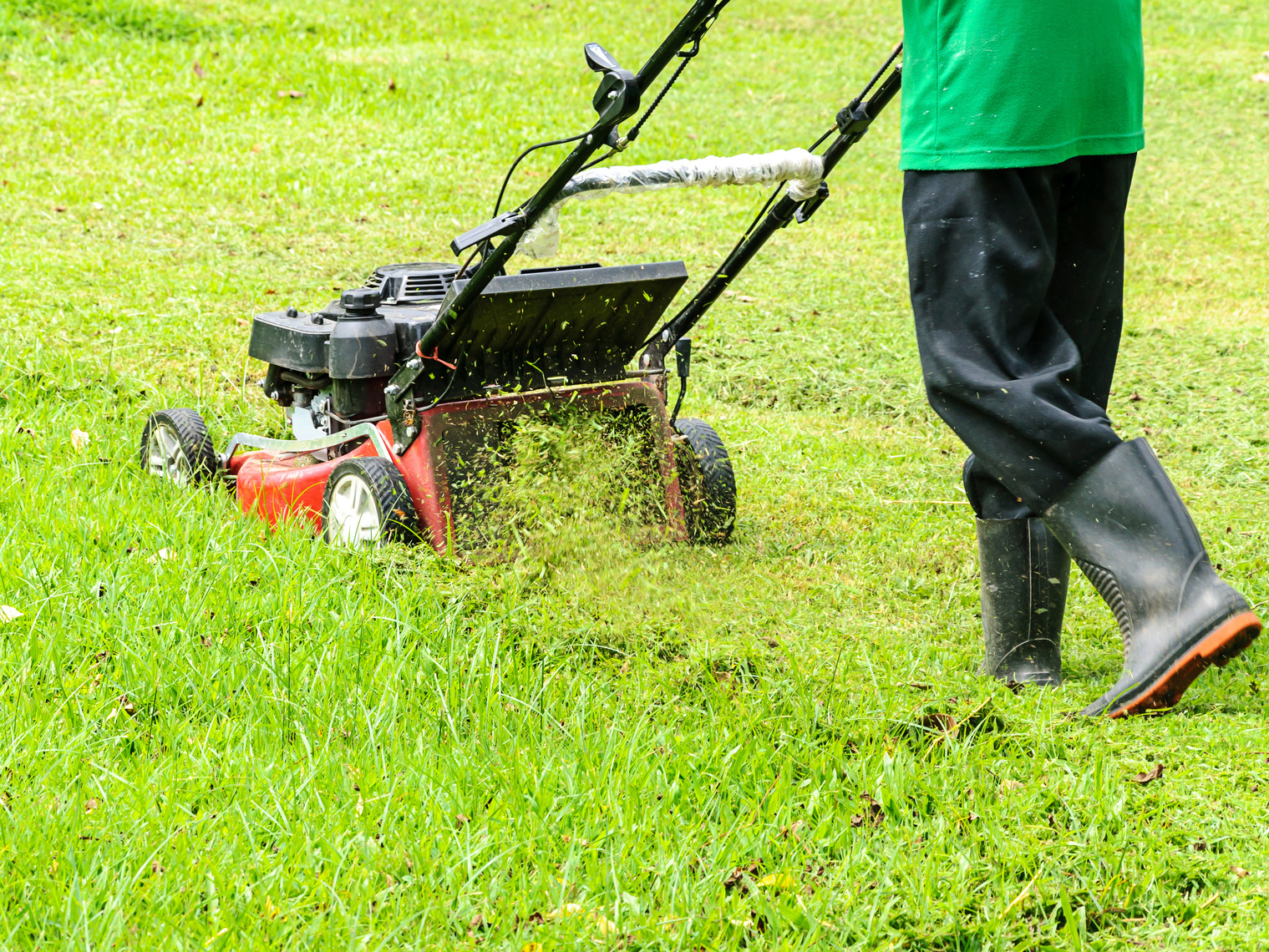 Worker mowing grass